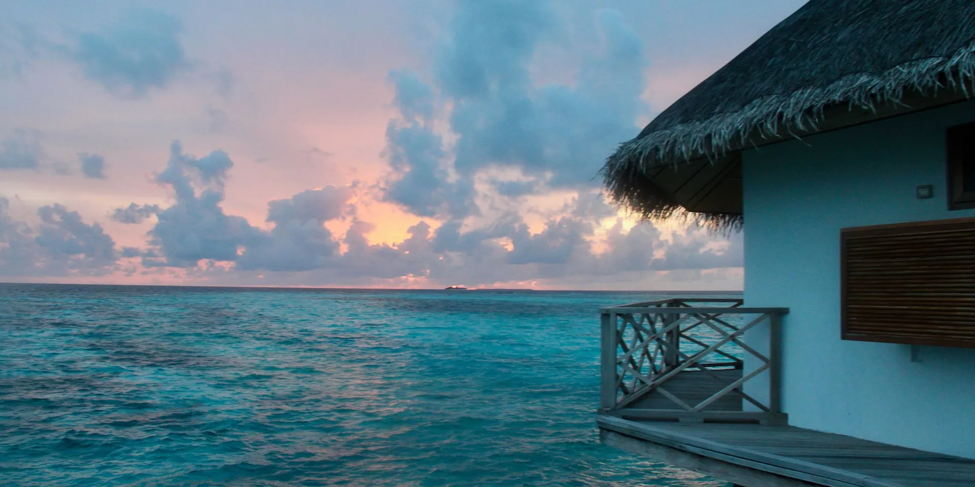 Overwaterbungalow op de Malediven bij zonsondergang